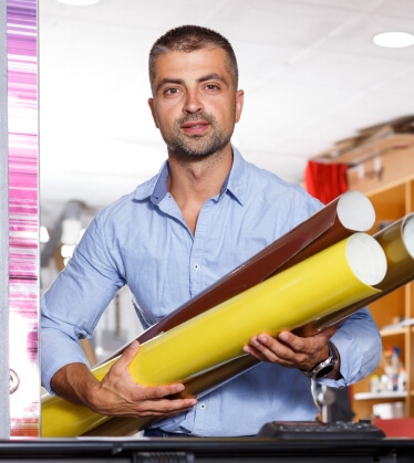 Large-format vinyl rolls in a print shop